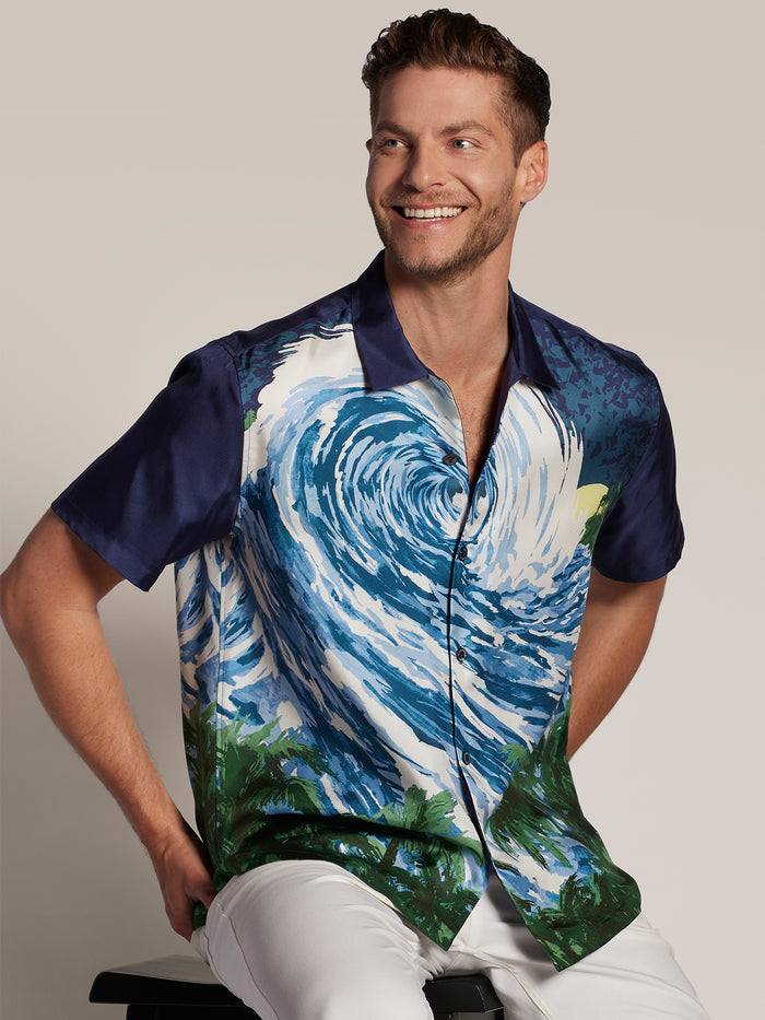 Blue and green wave-pattern silk shirt, seated front view.