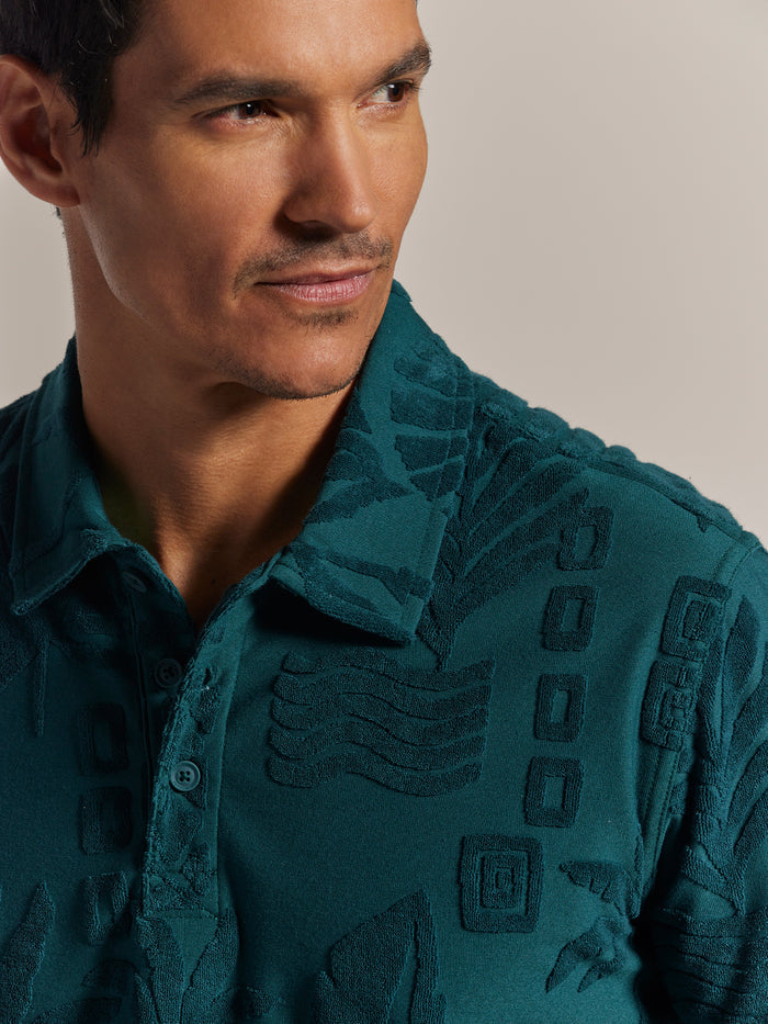 Teal 3D jacquard-texture polo shirt, side view on model, neutral background.