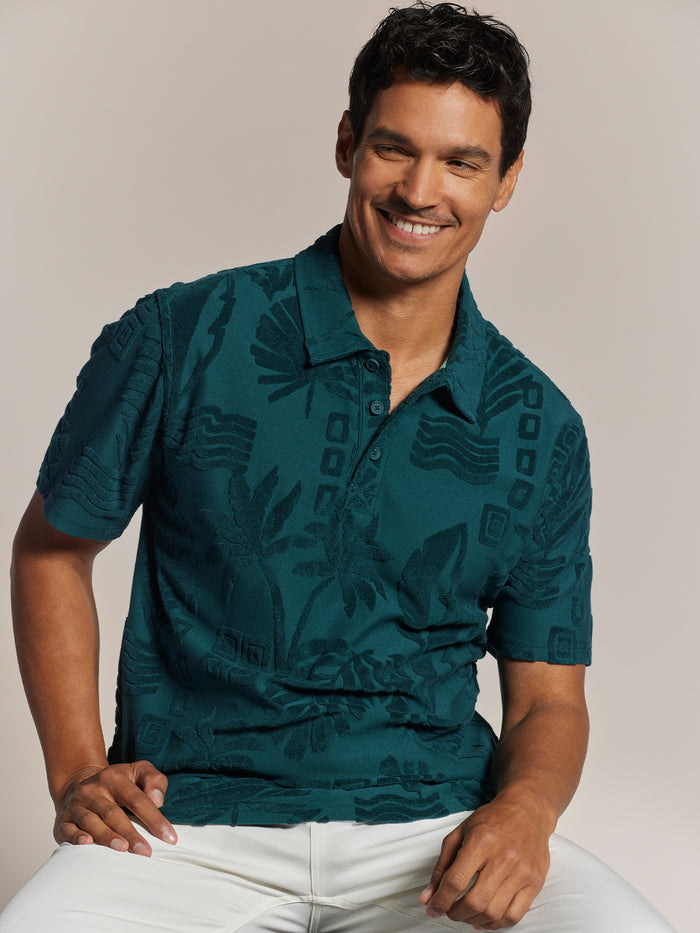 Teal 3D jacquard polo shirt, soft cotton, paired with white pants, front view.