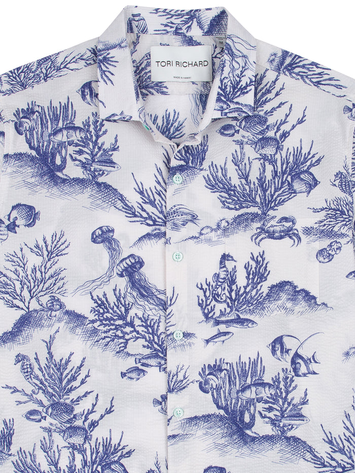 Blue fish-print cotton button-up shirt, front view, Hawaiian pucker texture.
