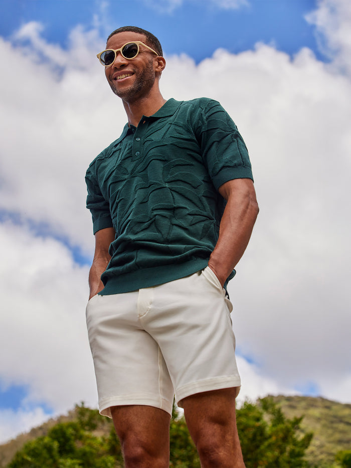 Dark Green palm-print sweater polo, outdoor front view on man in white shorts.