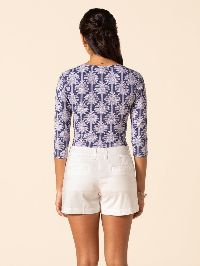 Navy palm-print bodysuit with three-quarter sleeves, back view, worn with white shorts.
