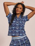 Navy short-sleeve polo shirt and blue and white palm-print, front view.