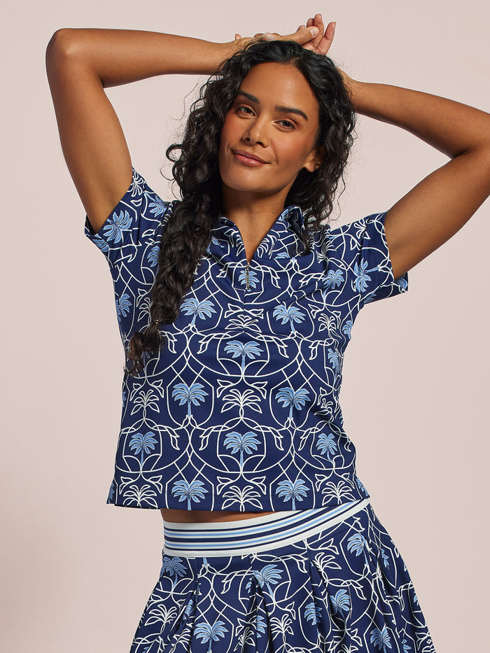 Navy short-sleeve polo shirt and blue and white palm-print, front view.