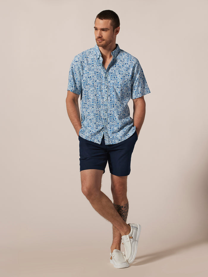 Blue Tradewind Technology® short-sleeve shirt and navy shorts, front view, hands in pockets.