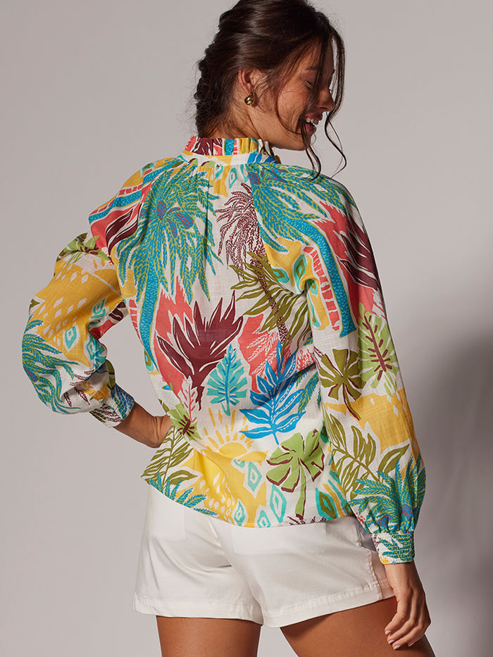 Multicolor tropical-print blouse and white shorts, back view on a model.