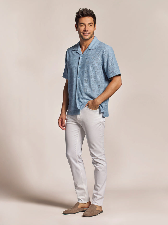 Light blue short-sleeve cabana shirt, white pants, brown loafers, full front view.