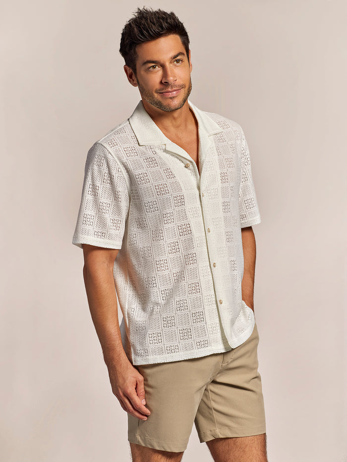 White breeze block-print button-up shirt with beige shorts, front view, hand in pocket.