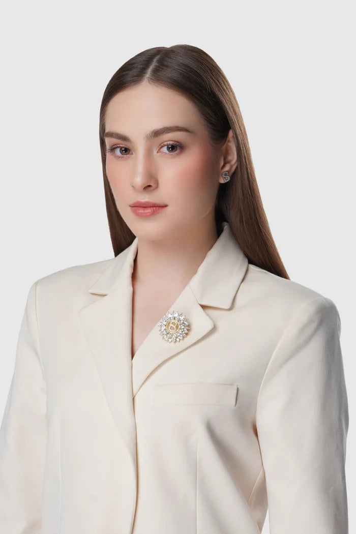gold raina brooch pinned to clothing