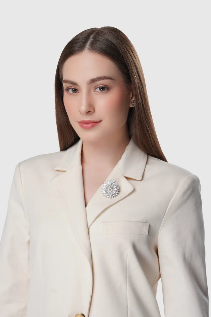 silver raina brooch pinned to clothing