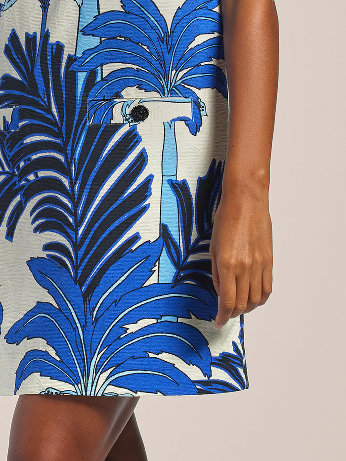 Blue dress with jeweled buttons, right-side view, arm relaxed at side.