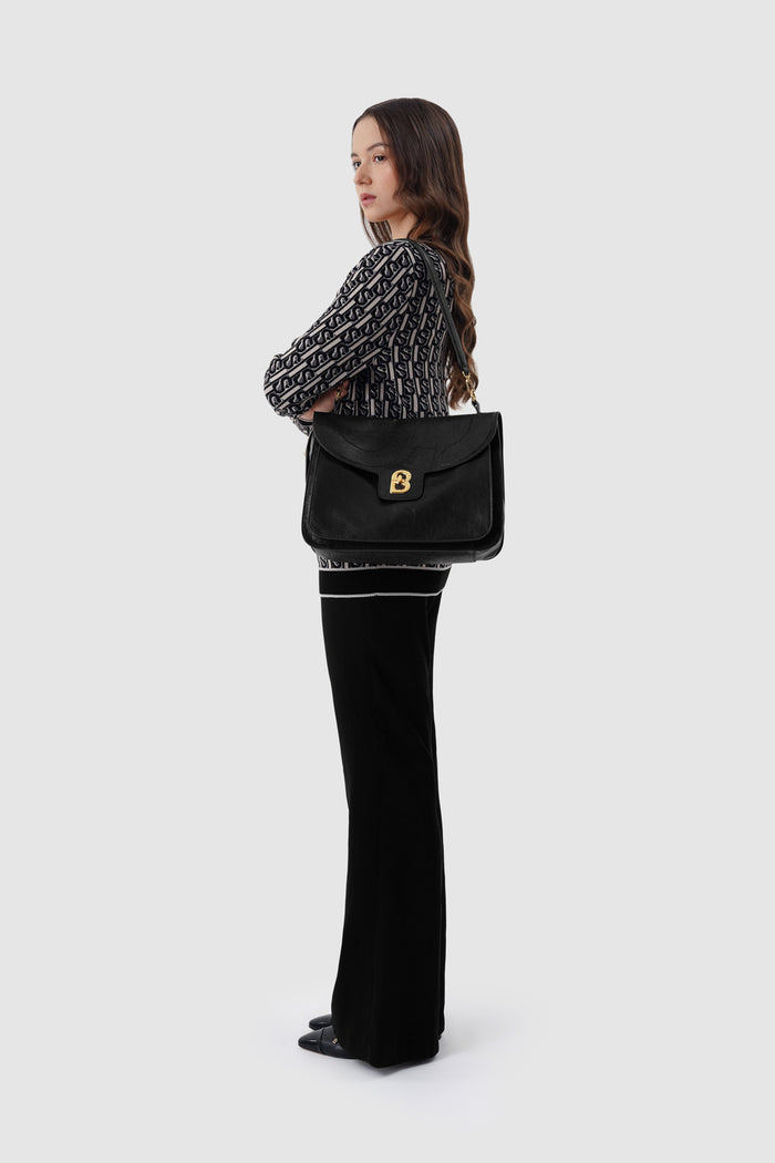 savina bag in black by buttonscarves carried on shoulder