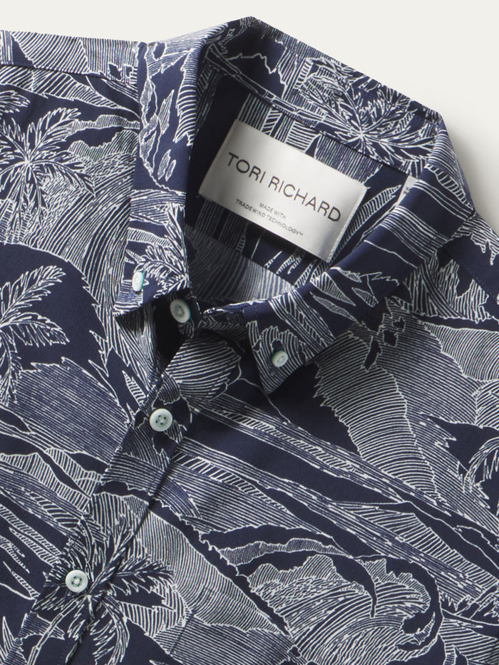 Navy shirt with white tropical print, short sleeves, UPF fabric, shown front and angled views.
