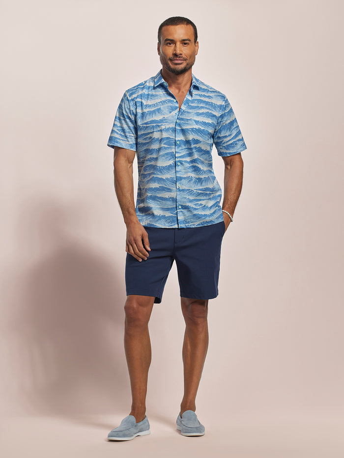 Sky Blue Ocean wave-print short-sleeve cotton shirt, navy shorts, loafers, front view, studio background.