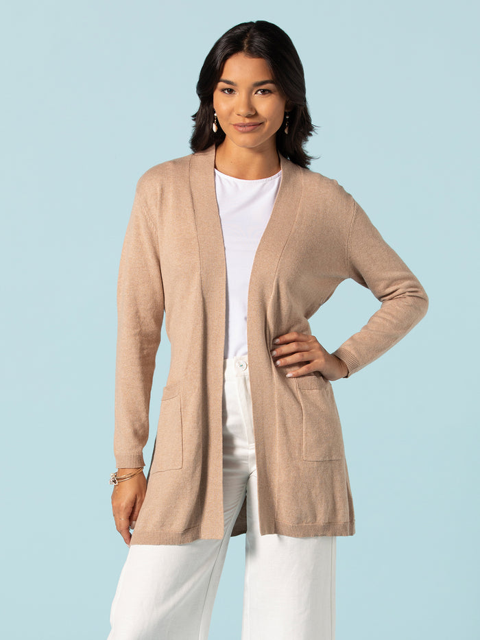 Beige Serenity Knits Inge Duster over white shirt and pants, standing front view.