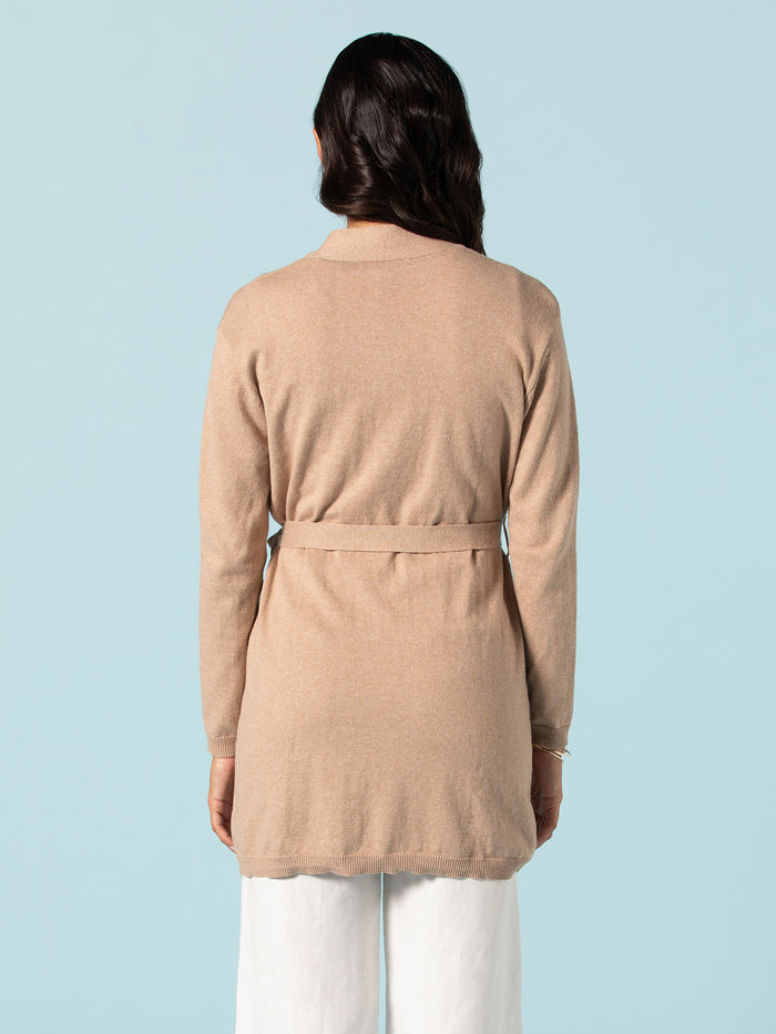 Beige duster, back view, with white pants on light blue background.