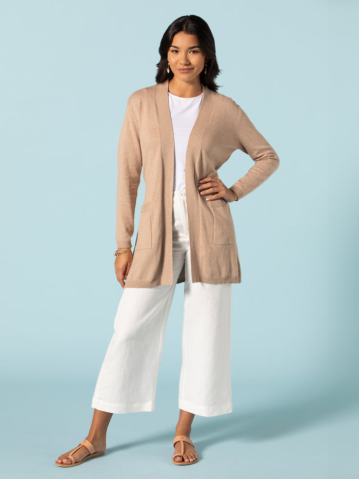 Beige long knit duster over white shirt and cream wide-leg pants, front view.