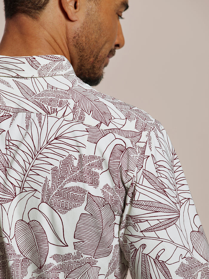 Maroon tropical leaf and cityscape-print short-sleeve shirt, back view.