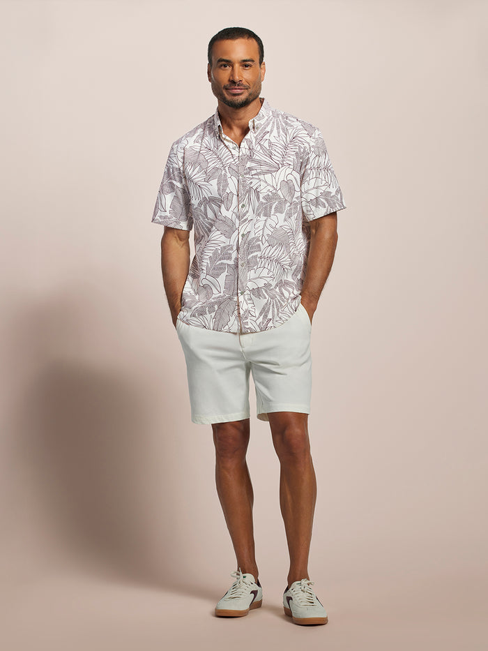 Off-white long-sleeve shirt with maroon leaf-print UPF with white shorts and sneakers, front view.