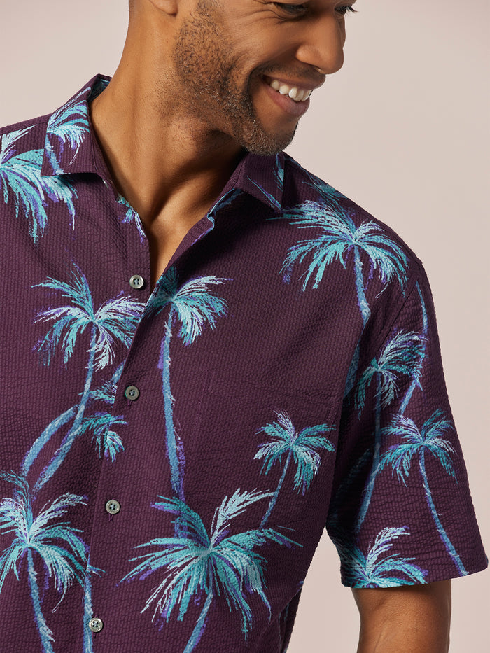 Purple and blue palm-print short-sleeve shirt, front view.