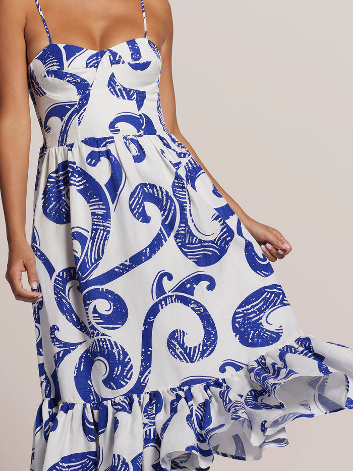 White and blue swirl-print midi dress with corset bodice and ruffled hem, skirt held out, front view{{/AltText}}.