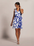 Blue and white swirl-print sleeveless dress, front view with white sandals.