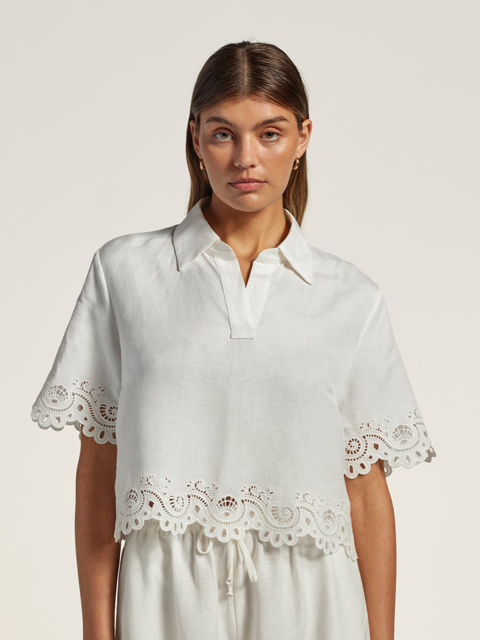 Yellow linen top with eyelet lace trim and white pants, front view (Image 1 & 2).