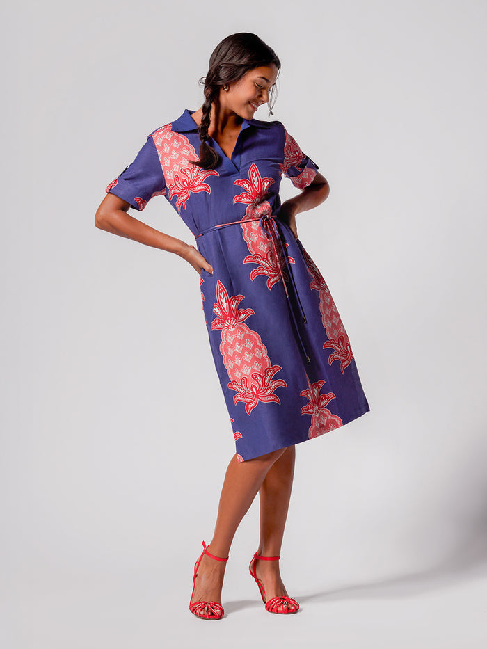 Blue dress with red pineapple print, double waist tie, front view.