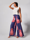White sleeveless top with Navy wide-leg pants with pink pineapple print, front view.