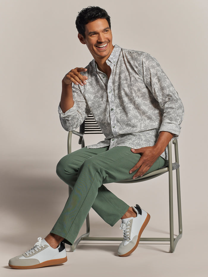 White long-sleeve Symmetree logo shirt and green pants, seated front view shown in both images.