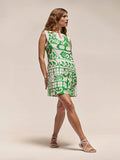 Green and white Polynesian-patterned sleeveless midi dress, front view, with white sandals.