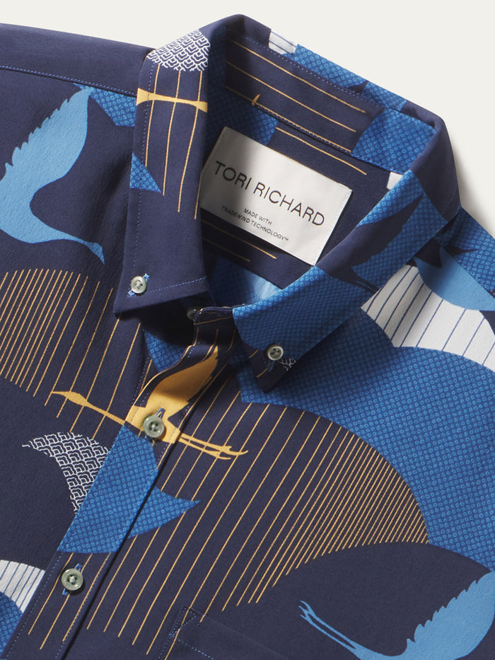 Blue crane-print long-sleeve shirt with gold-lined collar, close-up view.