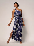 Navy and white floral Presley dress, front view; woman smiling, one arm bent, one leg forward.