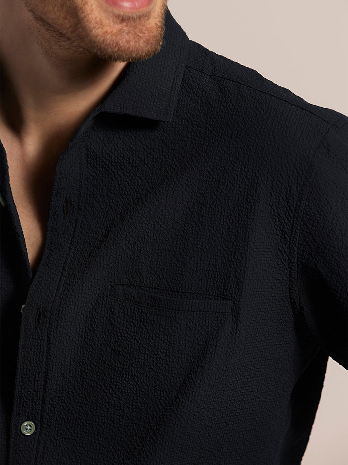 Black solid long-sleeve shirt, partial front view showing lower face smiling.