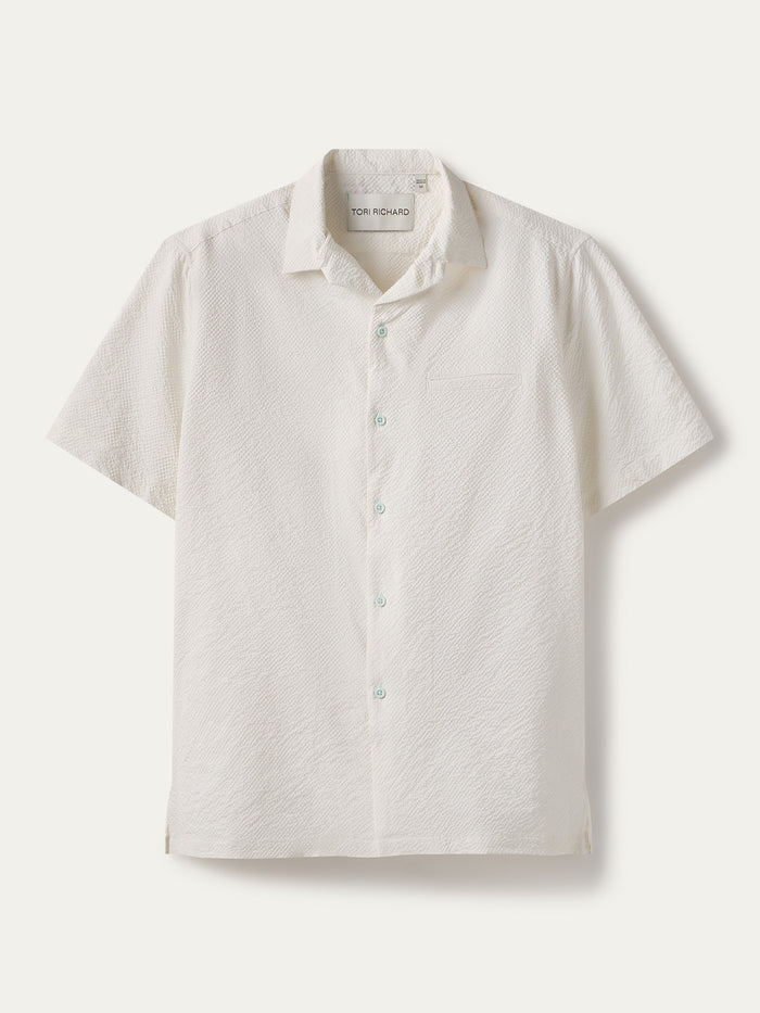 White solid short-sleeve cooling shirt with chest pocket, flat lay view.