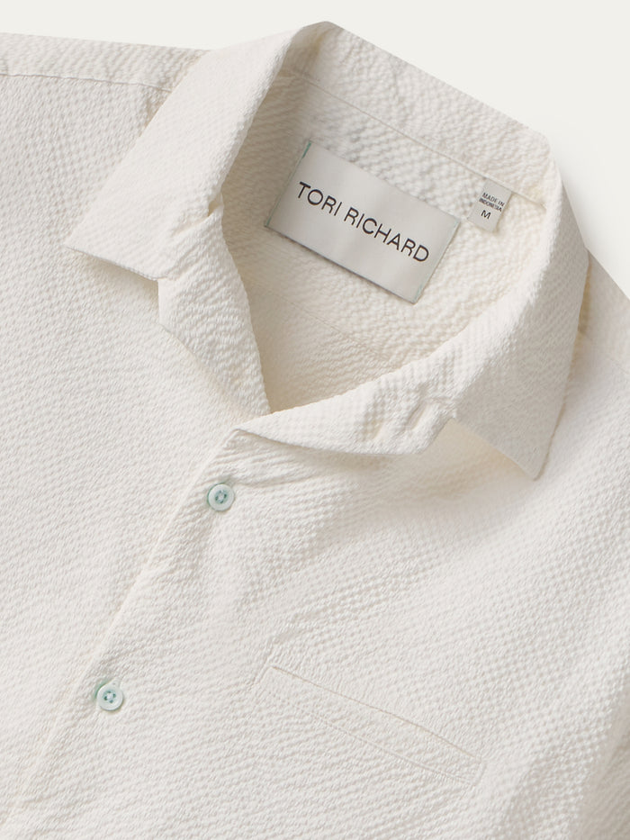 White textured short-sleeve shirt with collar and pocket, front view.