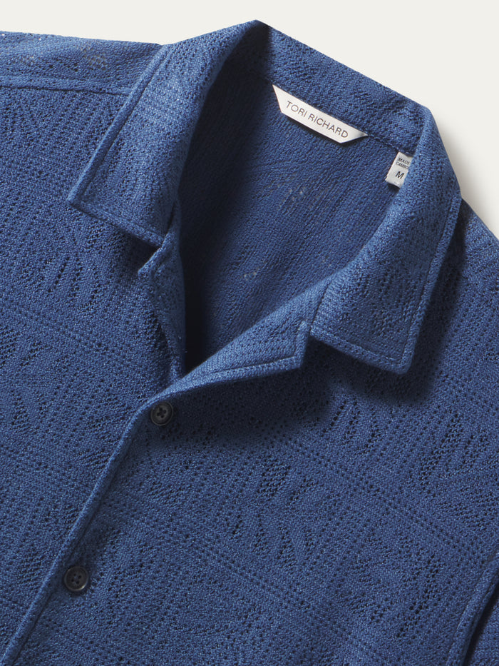 Blue textured button-up shirt with collar and visible neckline label, front view.