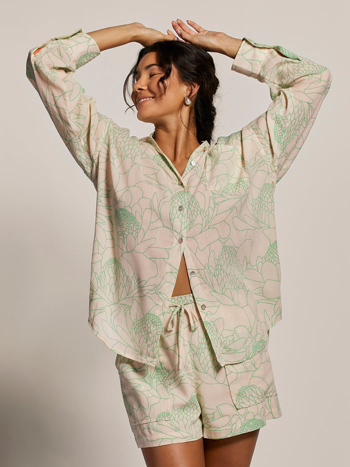 Cream with green floral print relaxed-fit boyfriend top and pastel shorts, front view, arms raised.