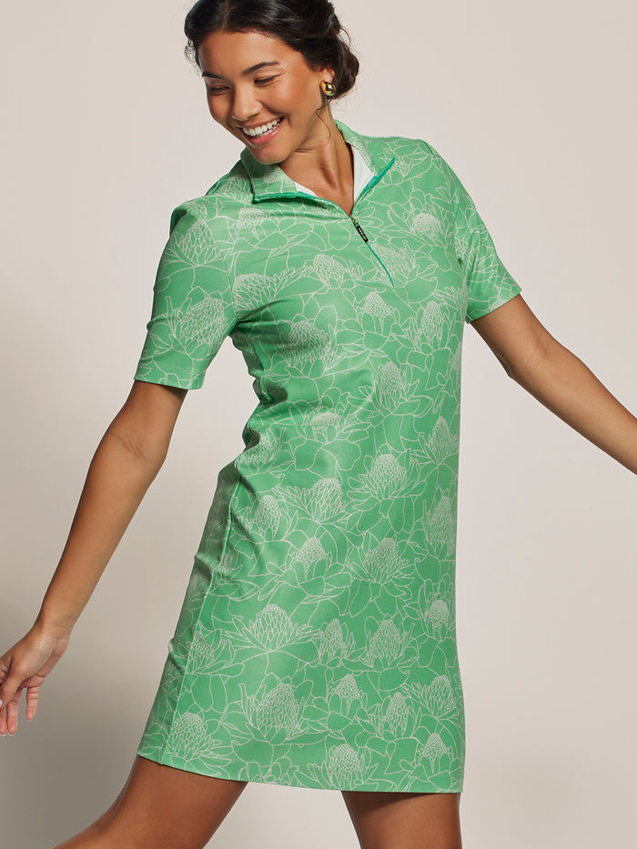 Green patterned maxi dress, front view with model’s arms out and looking down.