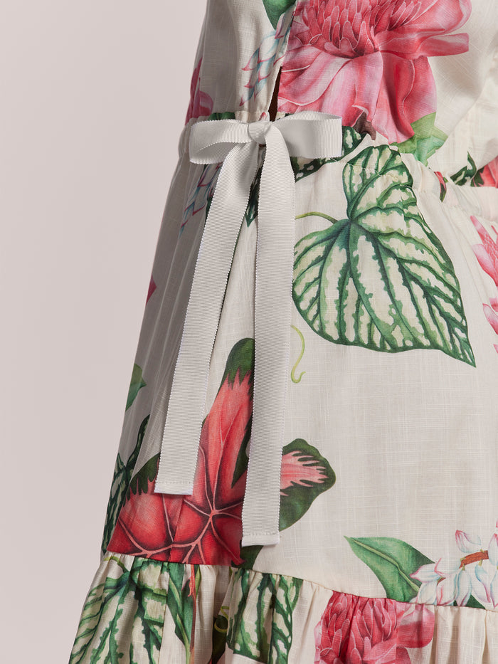 Light pink floral-print cotton voile mini dress with adjustable waist and white tie, front view.