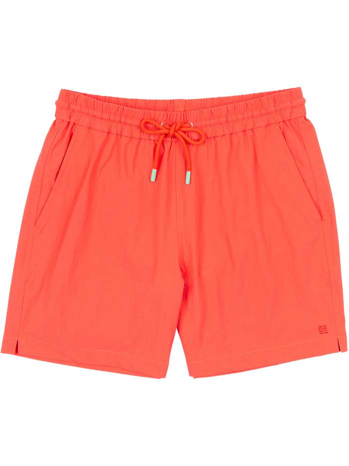 Bright orange swim shorts with elastic waist, side slits, pockets, and subtle logo detail. Front view flat lay.