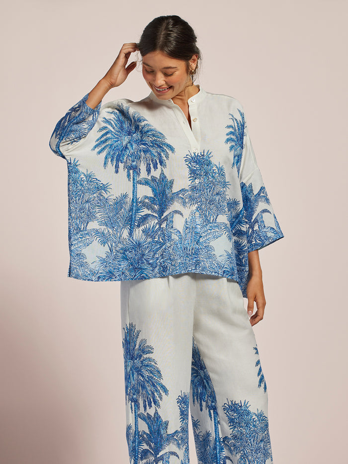 White and blue tropical palm-print kimono-sleeve shirt, front view.