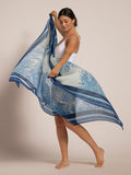 Blue and white tree-print pareo sarong tied at waist, side view, worn over white bodysuit.