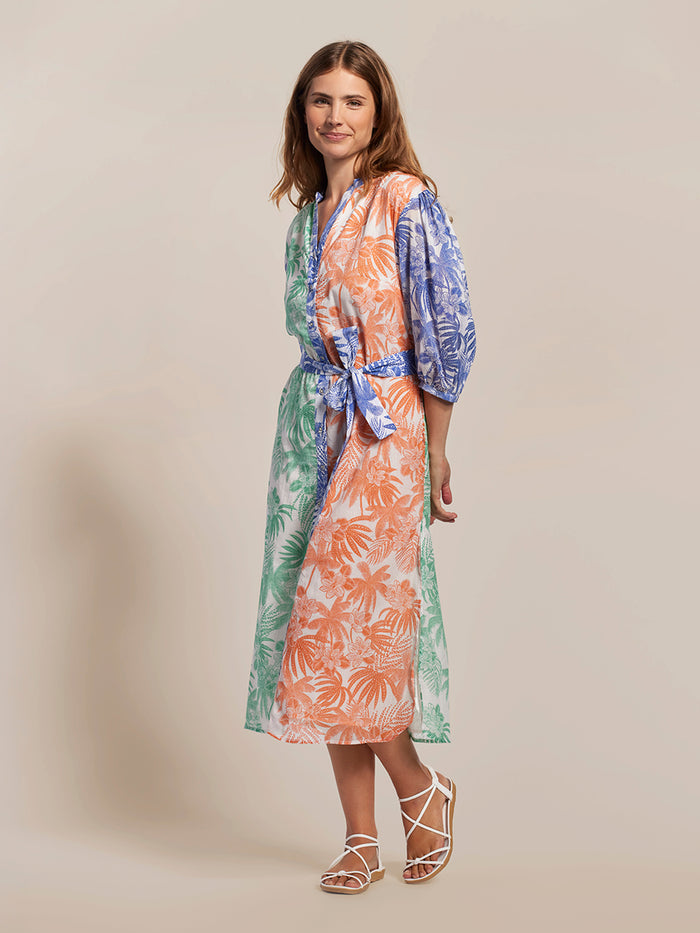 Multicolor tropical-print puff-sleeve dress with white sandals, front full-body view.