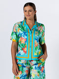 Multicolored floral short-sleeve button-up shirt, front view, hand in pocket.