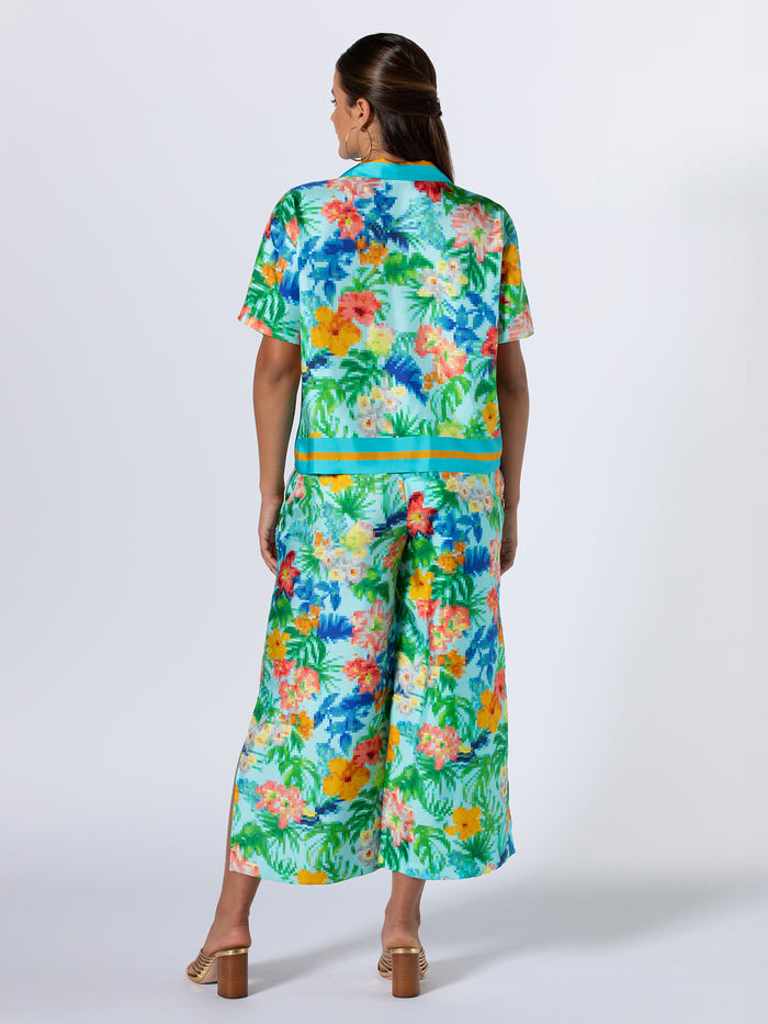 {{Tropical floral-print cabana top, back view, paired with heeled sandals against plain background}}.