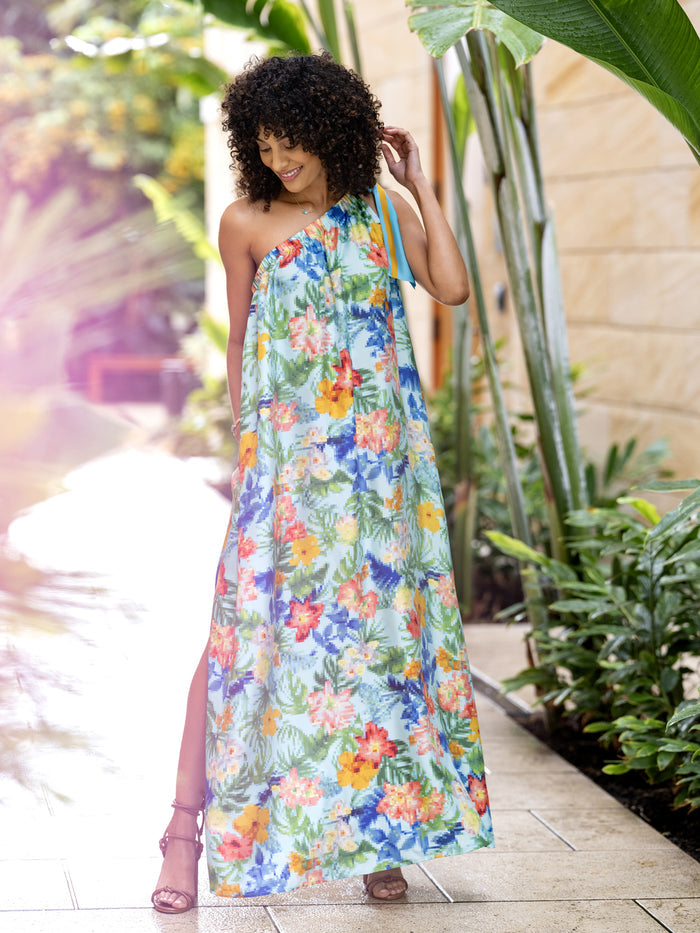 Multicolor tropical print Estrella midi dress, outdoor front view in lush greenery.