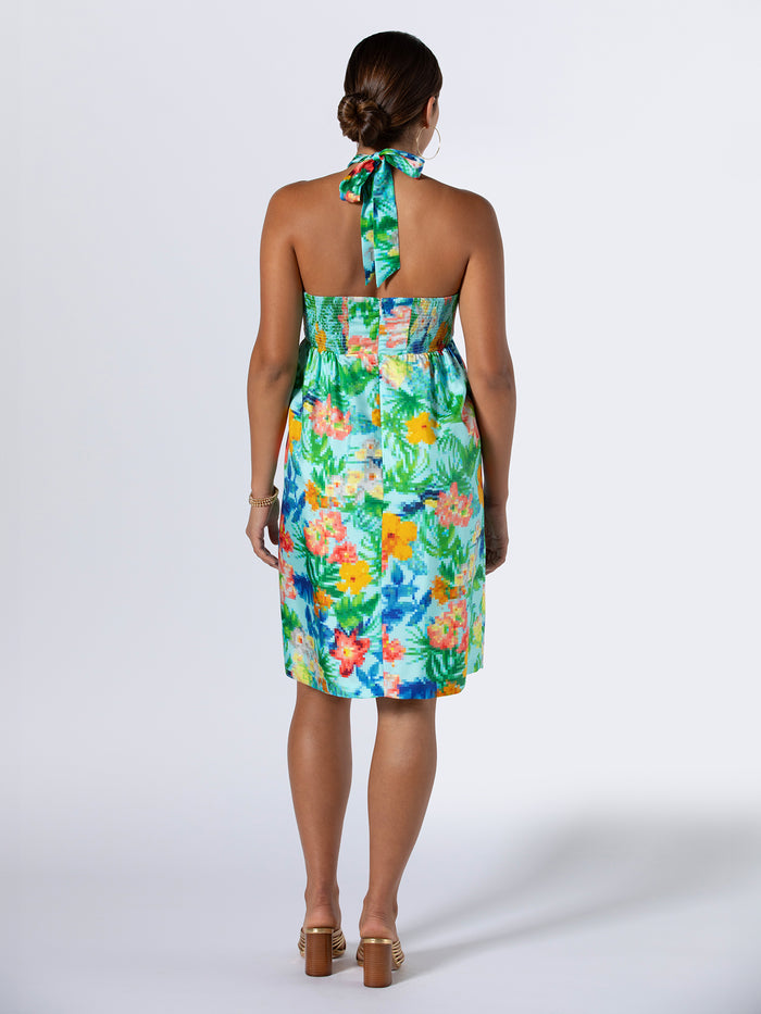 Magenta floral-print halter dress, back view, brown heels, low bun hairstyle.