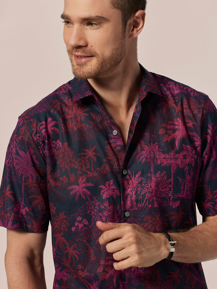 Dark purple and red palm tree print short-sleeve shirt, front view.