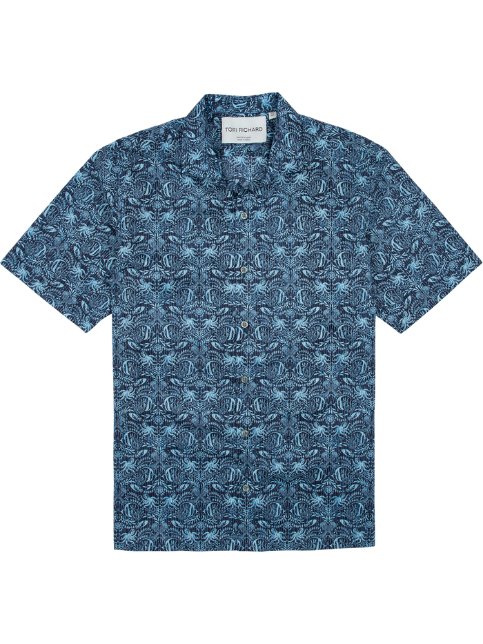 Blue and white mixed fishes-print short-sleeve cotton shirt, flat lay on white background.